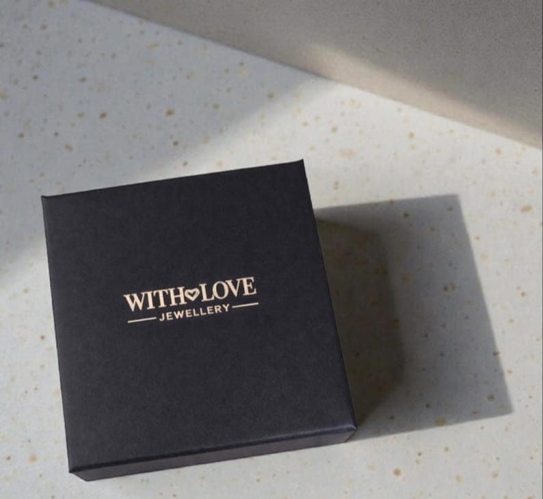 Black jewelry box with 'With Love Jewellery' logo on a textured surface