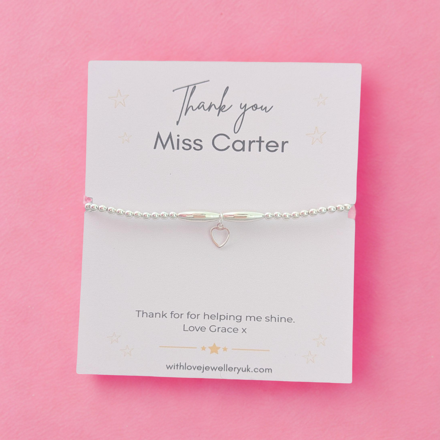 Silver bracelet on a personalized card with 'Thank you Miss Carter' text on a pink background