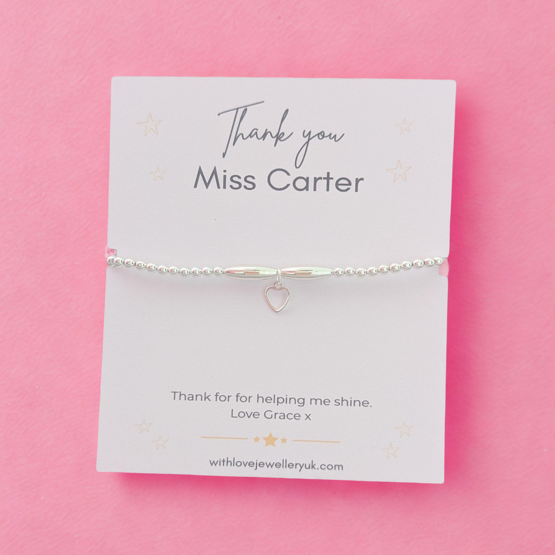 Silver bracelet on a personalized card with 'Thank you Miss Carter' text on a pink background