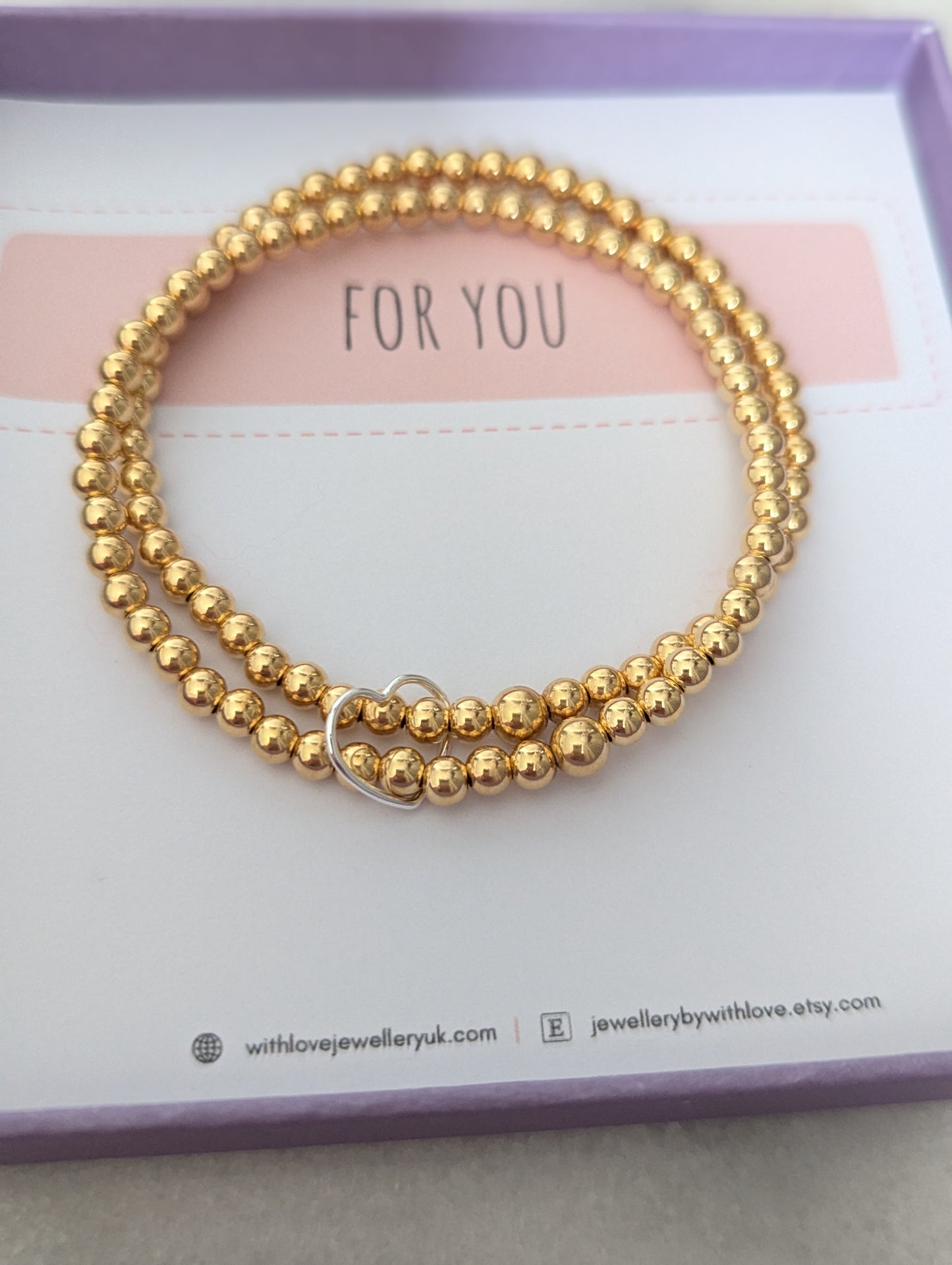 Double gold beaded bracelet, linked with a heart.