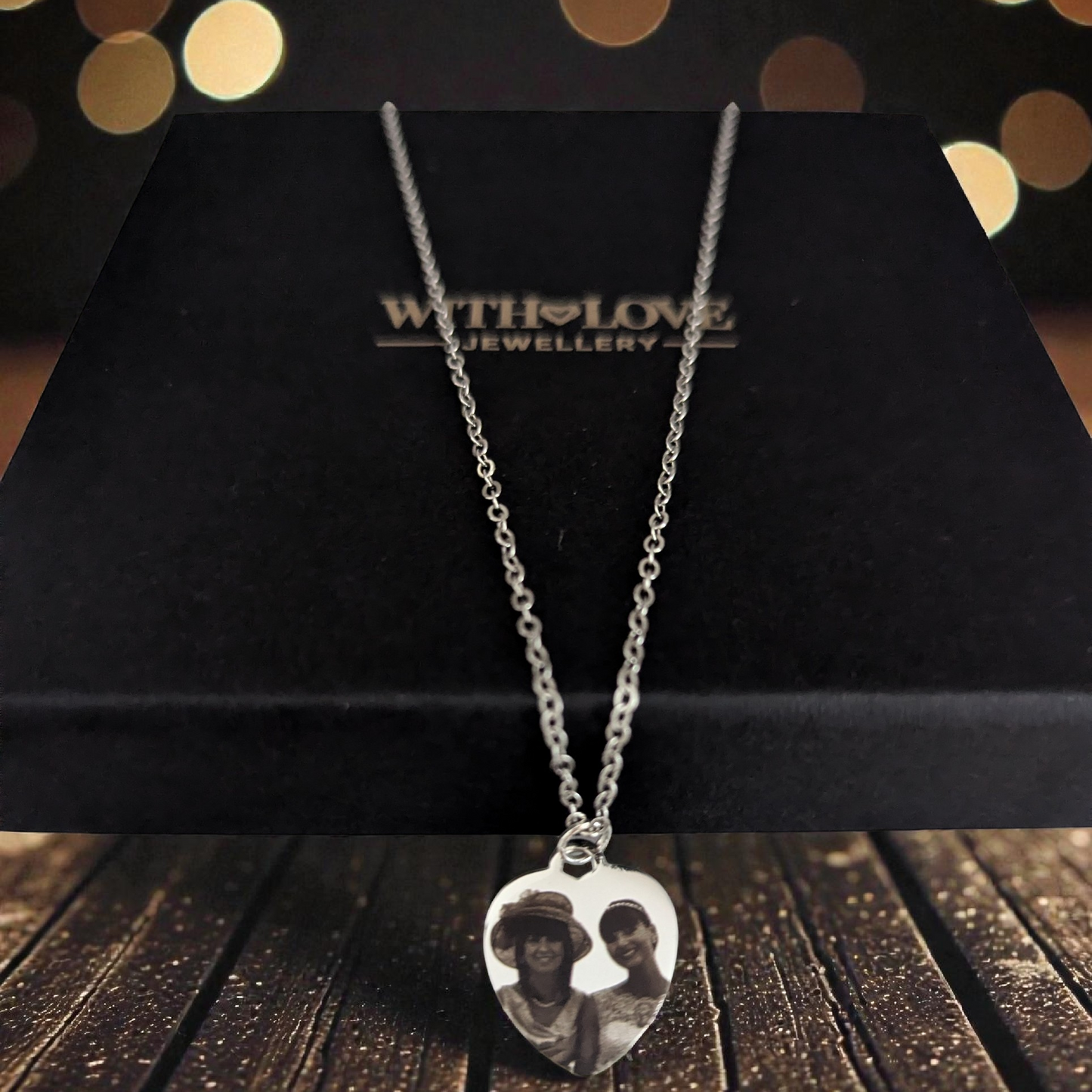 Silver necklace with a heart-shaped pendant on a black box with 'With Love Jewellery' branding.