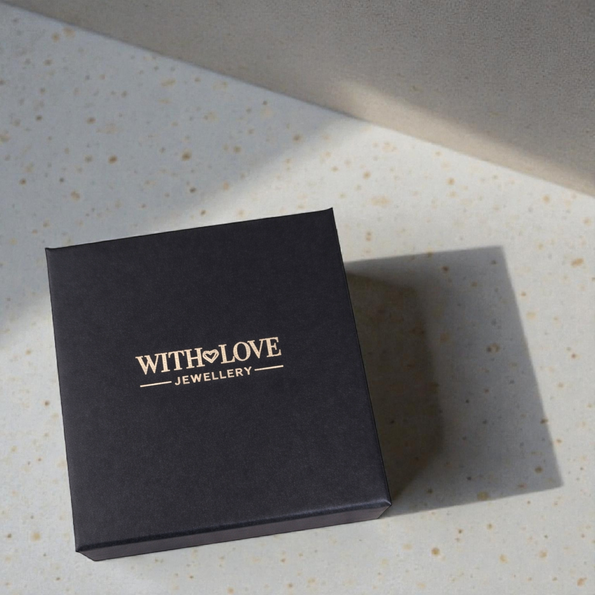 Black jewelry box with 'WITH LOVE JEWELLERY' logo on a textured surface