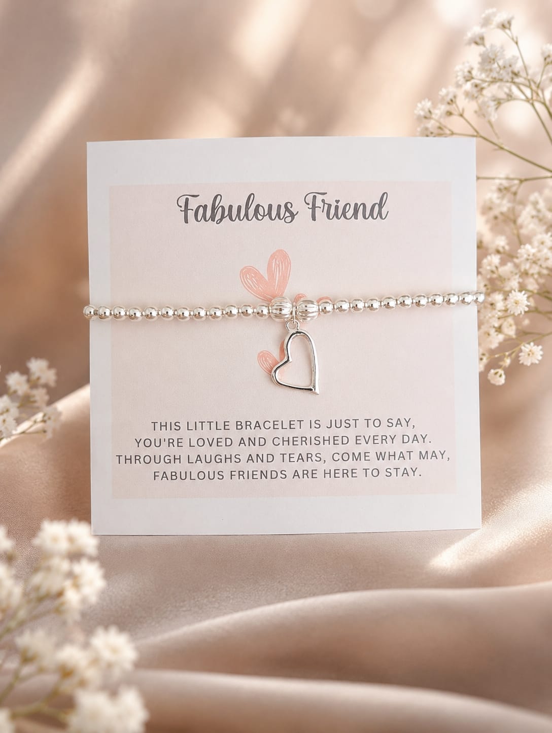 Bracelet with heart charm on a card labeled 'Fabulous Friend' surrounded by flowers.