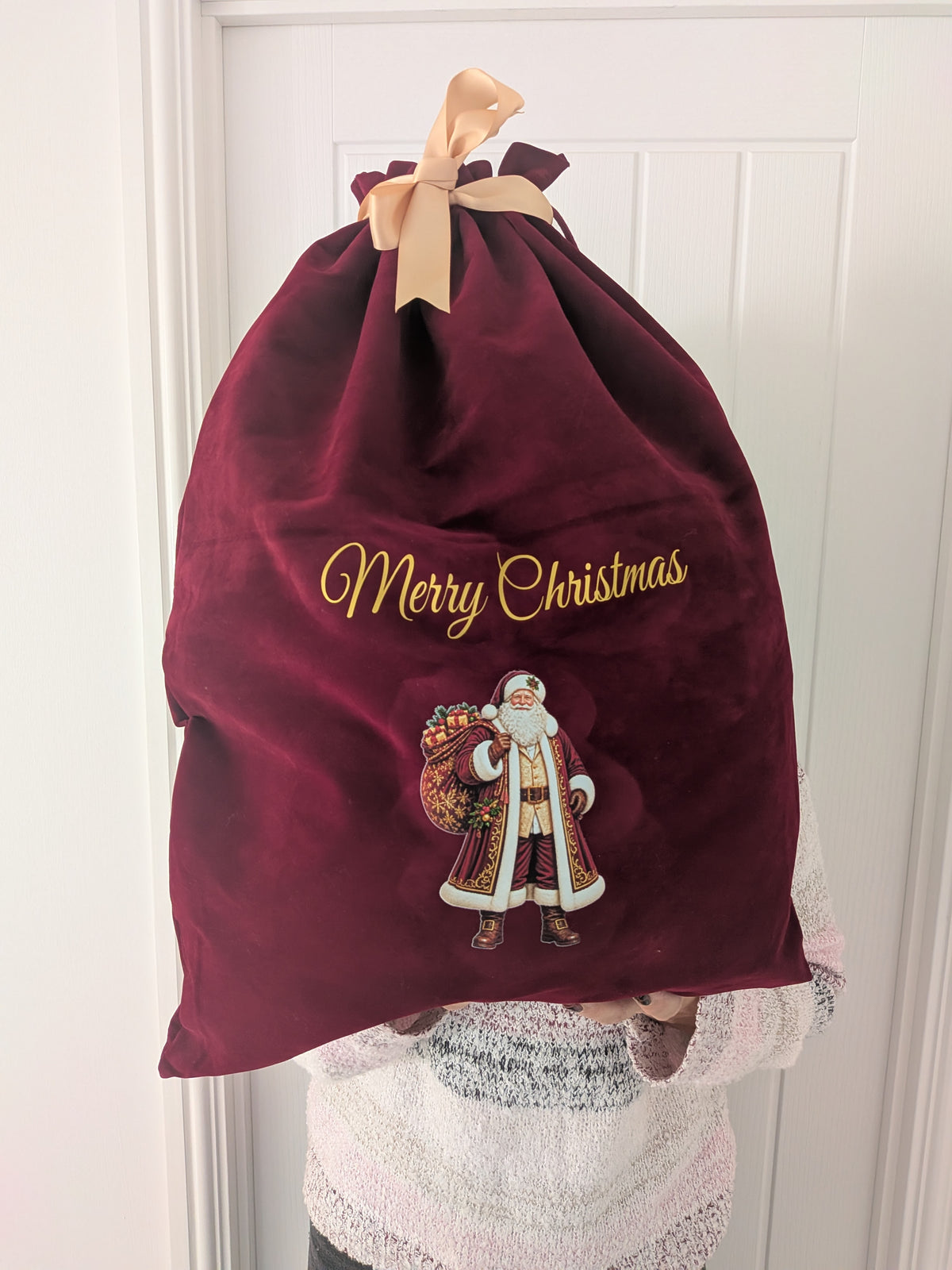 Personalised red velvet Christmas sack with gold lettering, Santa design and custom name, perfect for Christmas gifts.