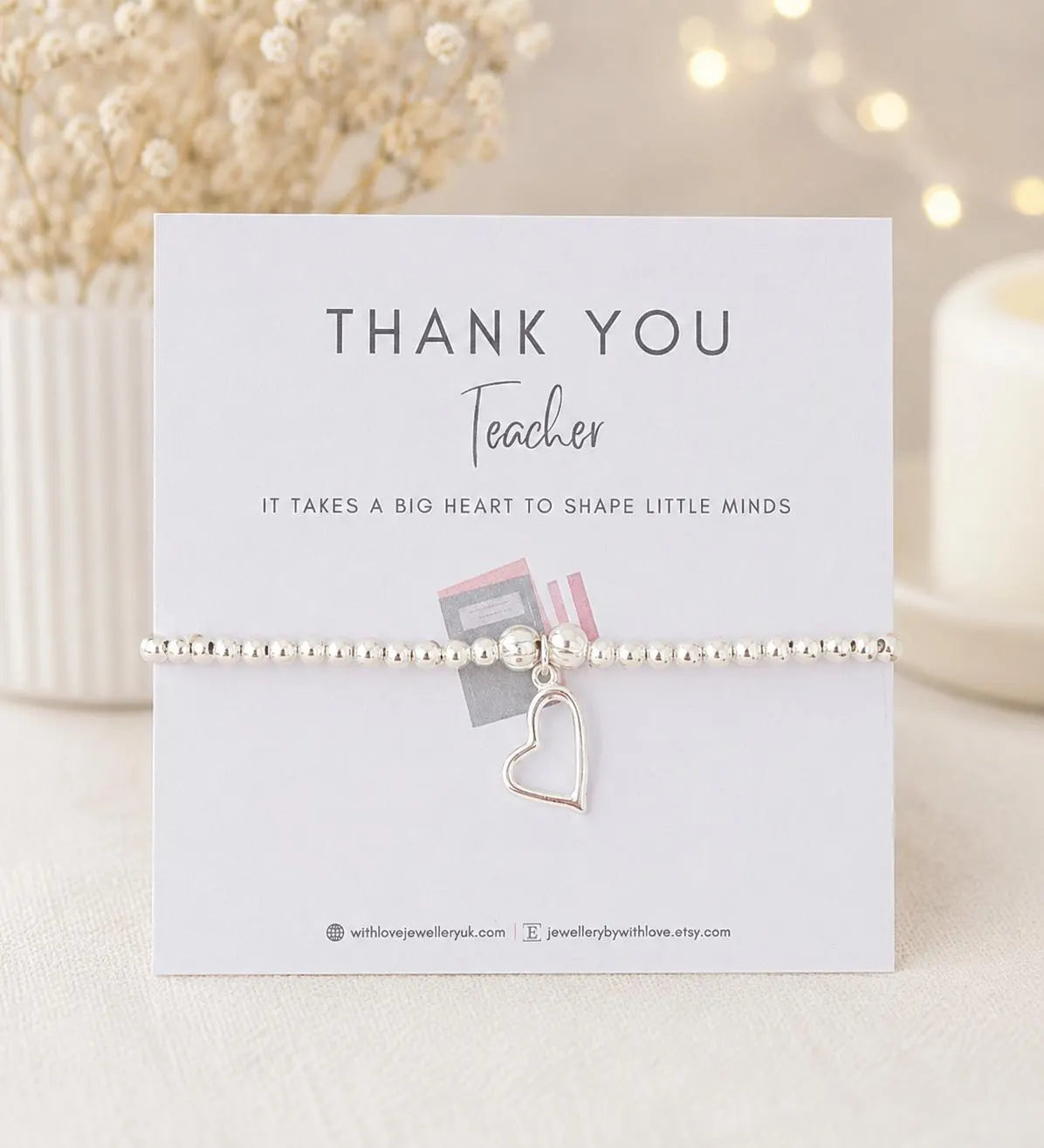Bracelet with heart charm on a 'Thank You Teacher' card with decorative background
